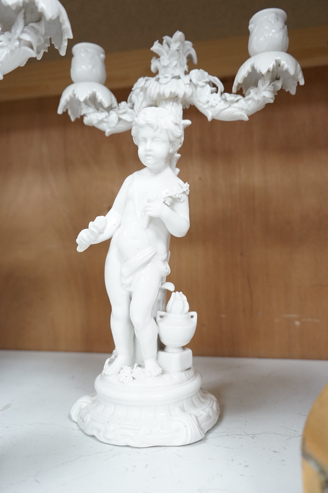 A pair of figural two branch candelabra, crossed swords marks, 36cm high